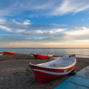 Small fishing boats on beach at sunset in Almunecar, Costa del Sol, Spain